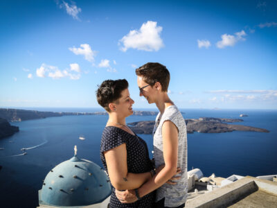 same sex marriage in Greece, two lesbian women looking at each other after their engagement. In Imerovigli with amazing caldera view, Santorini, Greece