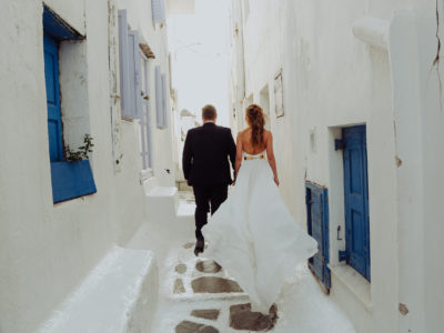 location portraiture of a bride and groom walking in the graphical alleys of Mykonos town