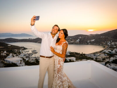 bride and groom having a selfie photograph at the terrace of Ios club at sunset time